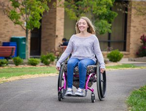 Woman gliding down a path in a wheelchair